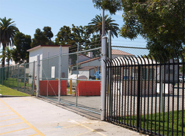 Large chain-link and iron wrought fence surrounding complex